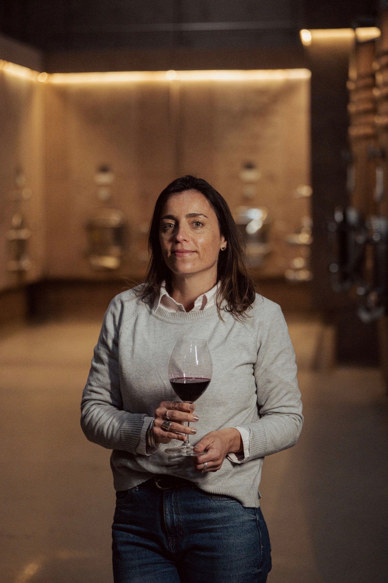 Juliana Bevilacqua con una copa de tinto en la sala de crianza